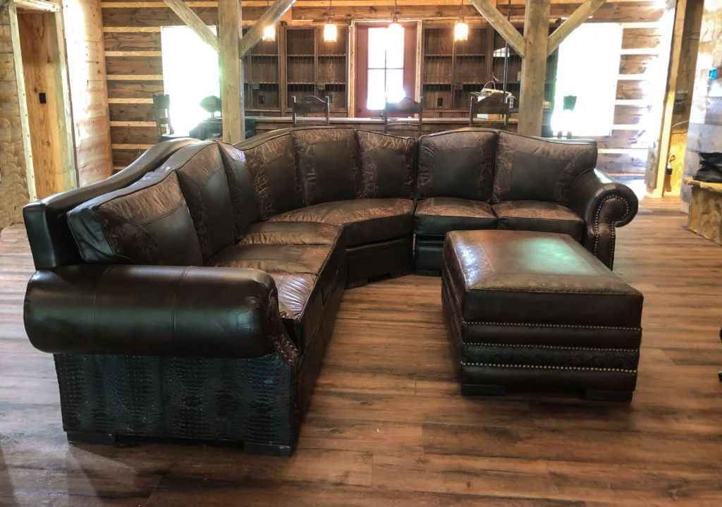 Bộ sofa da góc màu nâu sẫm trong không gian nhà gỗ