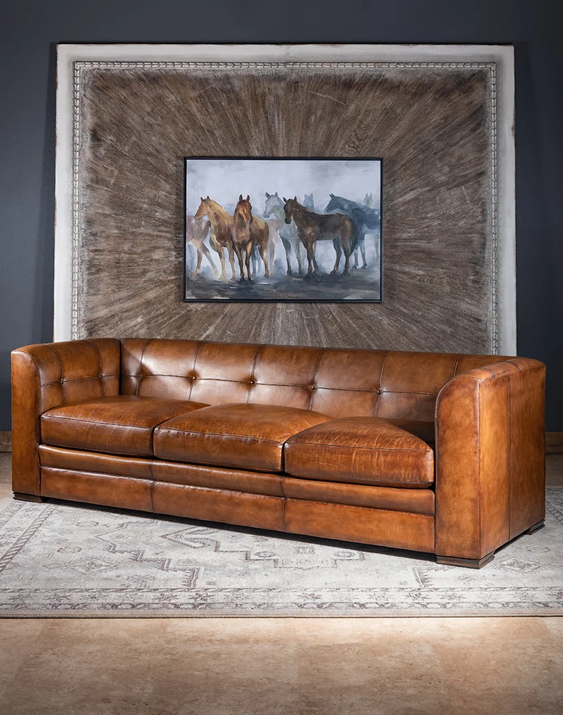 Sofa da nâu lớn trong phòng khách có tranh treo tường