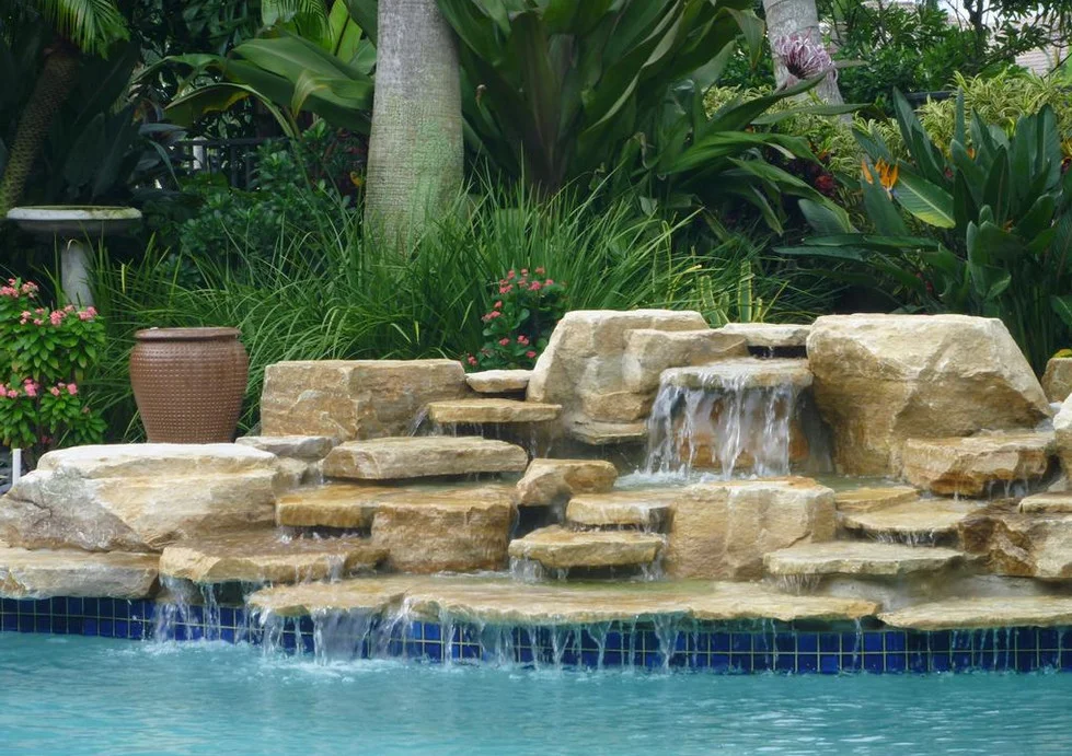Hình nền máy tính phong cảnh thác nước bằng đá bên hồ bơi xanh trong giữa khu vườn nhiệt đới