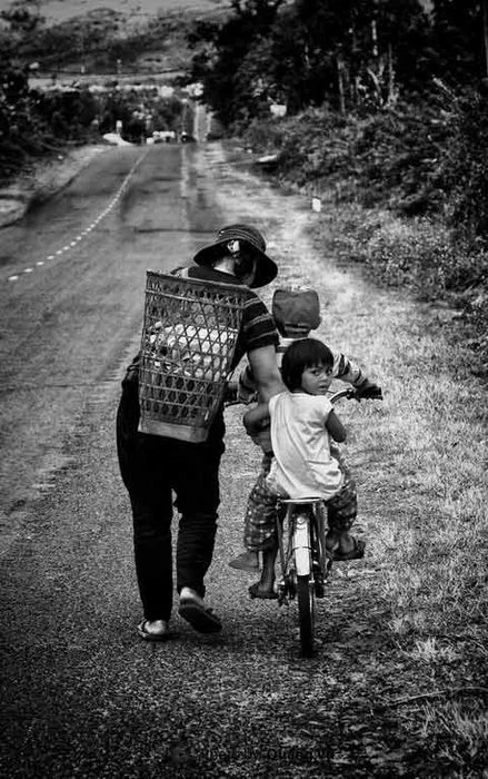 Người mẹ cõng con đi trên con đường vắng vẻ