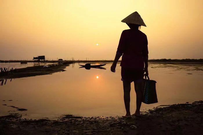 hình ảnh mẹ đội nón lá bên bờ sông lúc hoàng hôn
