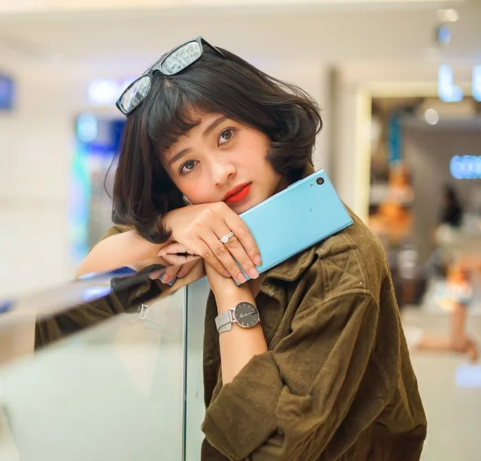 cô gái xinh ngầu cầm điện thoại tạo dáng