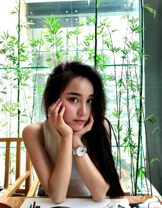 cô gái xinh ngầu chống cằm tạo dáng bên cửa sổ